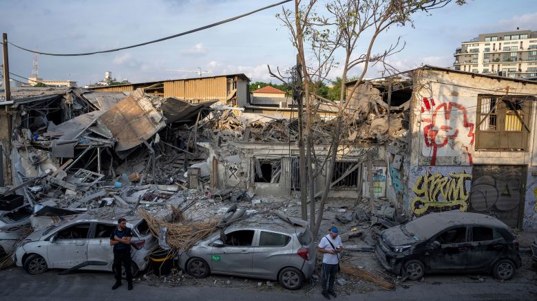 Israelis inspect the rubble of a building a day after it was hit by a rocket fired from Gaza, in Tel Aviv, Israel, Sunday, Oct. 8, 2023. The militant Hamas rulers of the Gaza Strip carried out an unprecedented, multi-front attack on Israel at daybreak Saturday, firing thousands of rockets as dozens of Hamas fighters infiltrated the heavily fortified border in several locations by air, land, and sea, killing hundreds and taking captives. Palestinian health officials reported scores of deaths from Israeli airstrikes in Gaza. (AP Photo/Oded Balilty)