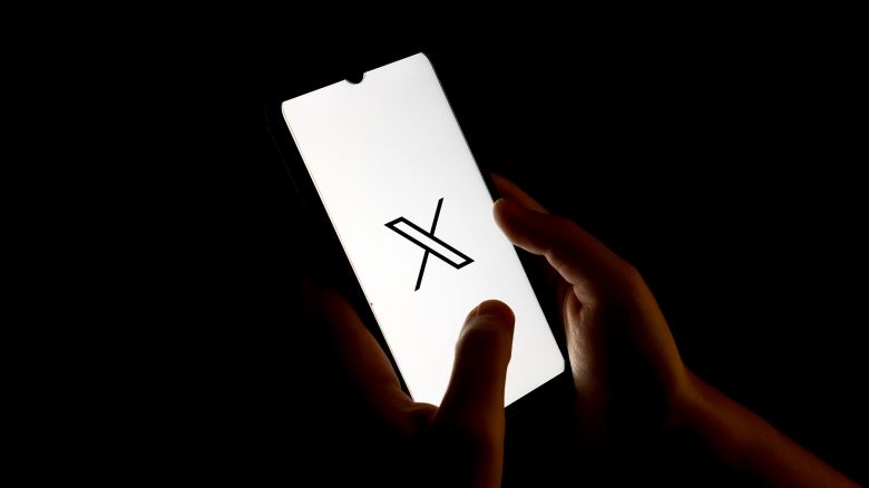 An X (formerly Twitter) logo is displayed on a smartphone screen.