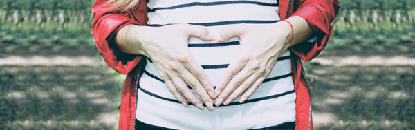 Pregnant woman with her hands in the shape of a heart on her belly, Skincare and Pregnancy from Osmosis Beauty